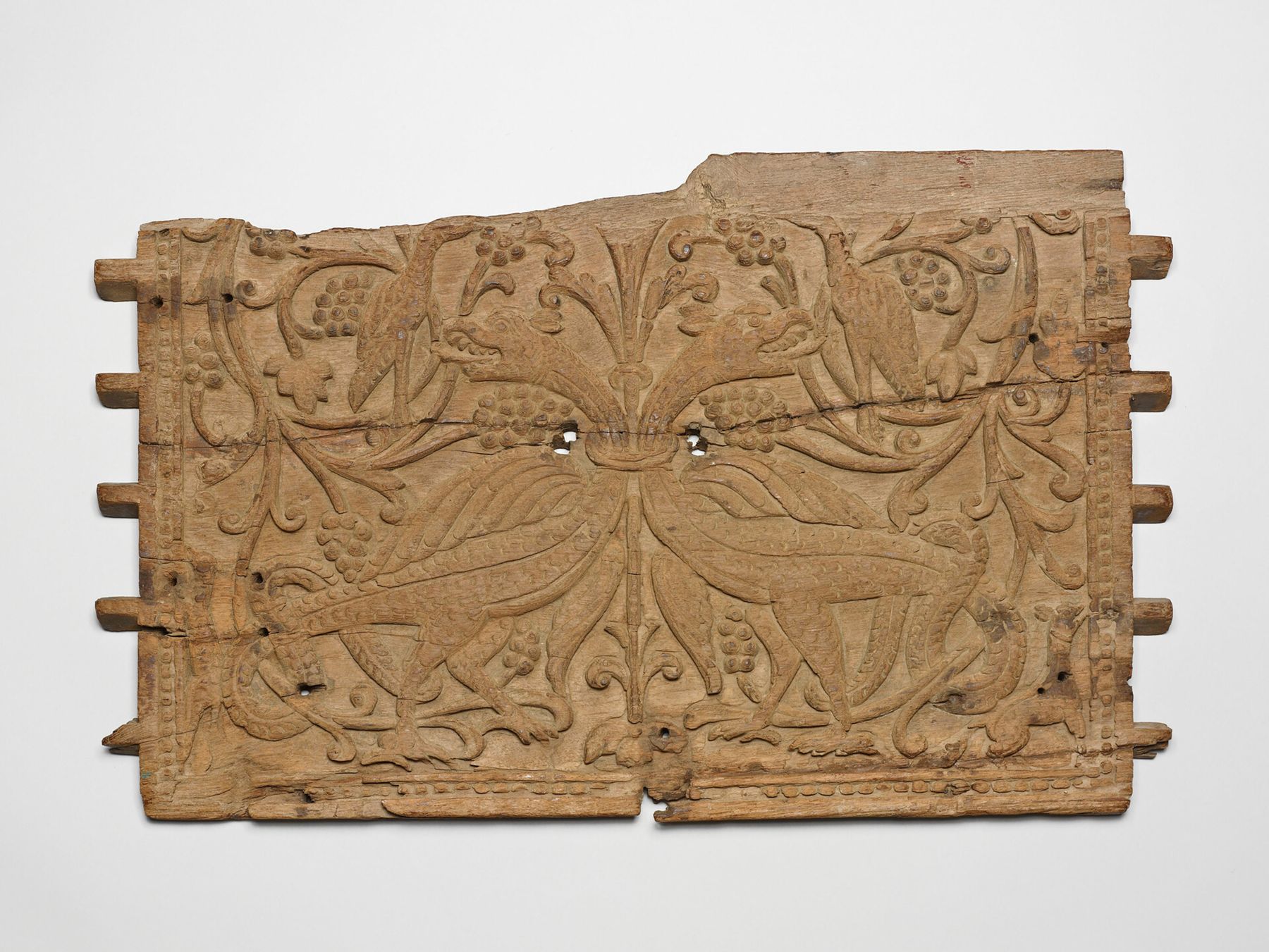 A sixteenth-century Indian carved wooden panel with two birds among vines